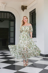 a lady in a light green silk dress with floral print on it